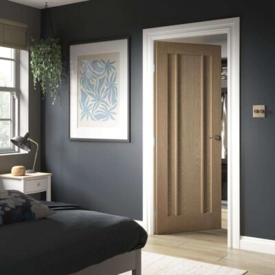 Howdens Worcester Oak three-panel door fitted in a dark bedroom